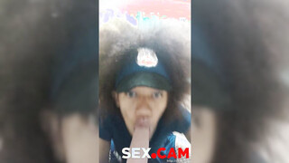 Curly police officer with blue eyes sucks a big dildo for her colleagues.